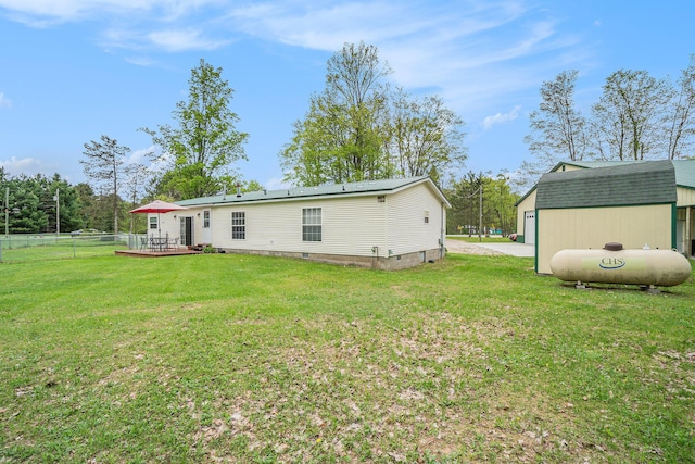 8978 Starvation Lake Rd, Mancelona, MI 49659 - rear view of house featuring an outbuilding, a wooden deck, and crawl space