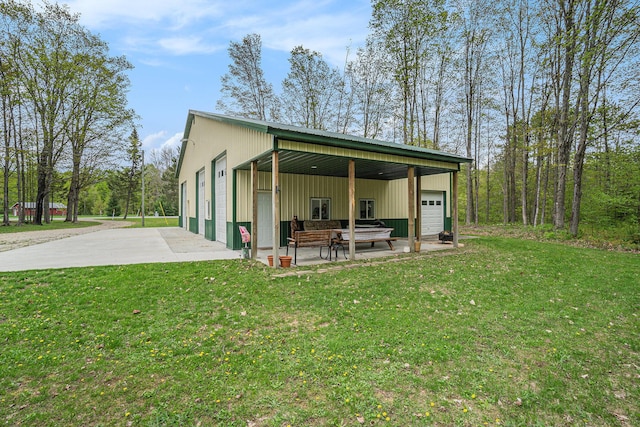 8978 Starvation Lake Rd, Mancelona, MI 49659 - back of house with a lawn, a detached garage, and an outdoor structure