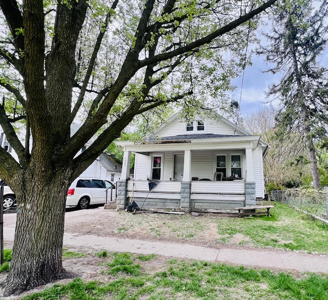 view of front of home with a porch and fence