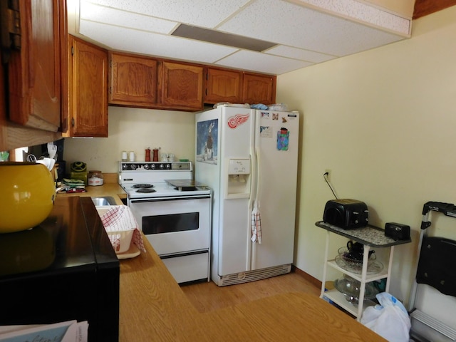 8727 S Oak Rd, Grayling, MI 49738 - kitchen with white appliances, light countertops, light wood-type flooring, and brown cabinetry