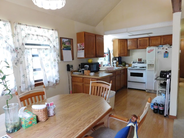 8727 S Oak Rd, Grayling, MI 49738 - kitchen with white appliances, lofted ceiling, light wood finished floors, brown cabinets, and light countertops