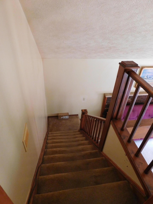 8727 S Oak Rd, Grayling, MI 49738 - staircase with a textured ceiling and baseboards
