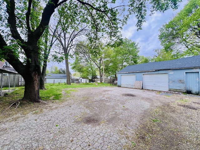 detached garage featuring fence