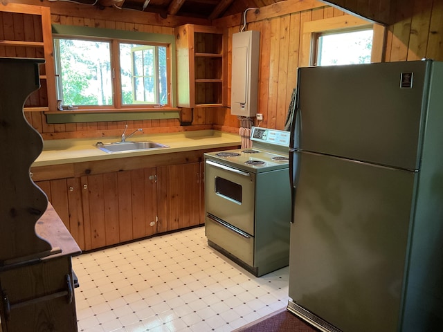 8842 Jackson Hole Trl, Grayling, MI 49738 - kitchen with freestanding refrigerator, white electric range oven, open shelves, healthy amount of natural light, and lofted ceiling