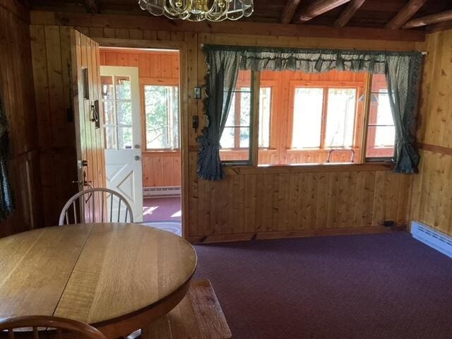 8842 Jackson Hole Trl, Grayling, MI 49738 - dining area with wood walls, baseboard heating, carpet flooring, a chandelier, and beam ceiling