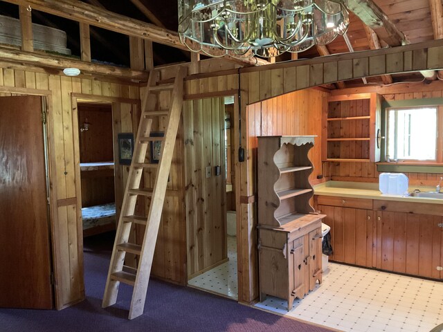 8842 Jackson Hole Trl, Grayling, MI 49738 - misc room with wooden walls, a chandelier, and light colored carpet