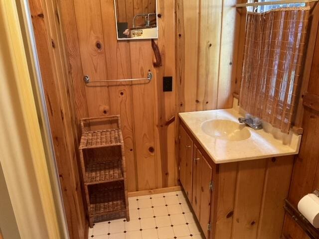 8842 Jackson Hole Trl, Grayling, MI 49738 - bathroom with tile patterned floors, vanity, and wooden walls