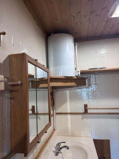 3120 Wilds Rd, Ossineke, MI 49766 - bathroom featuring a sink, decorative backsplash, wooden ceiling, and tile walls