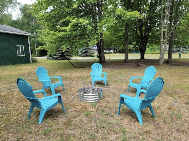 301 Hugh St, East Jordan, MI 49727 - view of grassy yard with an outdoor fire pit and view of wooded area