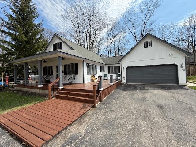 view of front of house featuring a garage, asphalt driveway, and covered porch