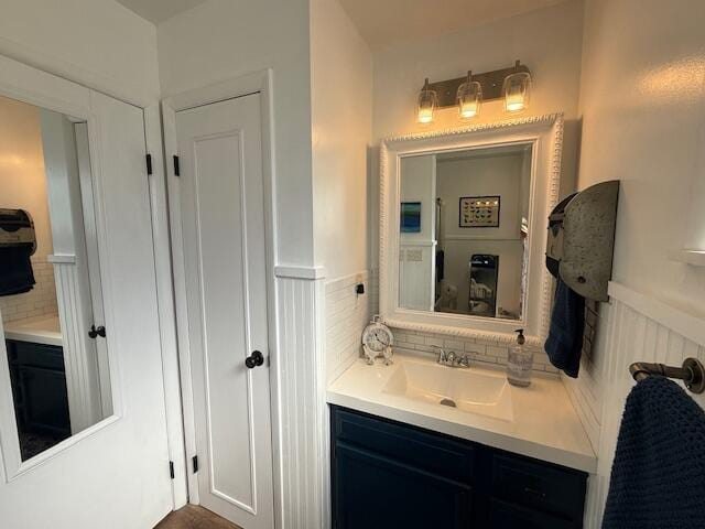 bathroom with wainscoting, decorative backsplash, and vanity