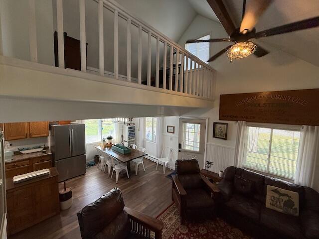 living area featuring high vaulted ceiling, a ceiling fan, plenty of natural light, and wood finished floors
