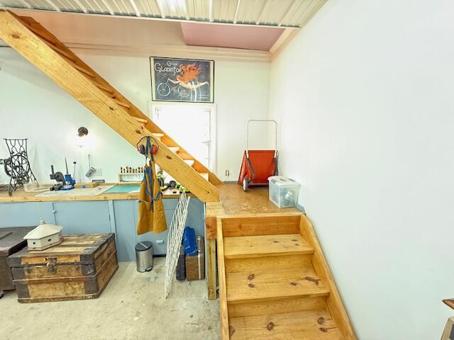 stairs with concrete floors and a workshop area