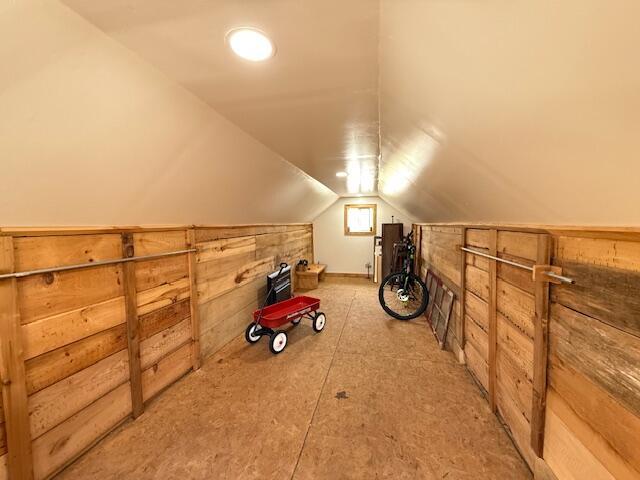 bonus room featuring wood walls and vaulted ceiling