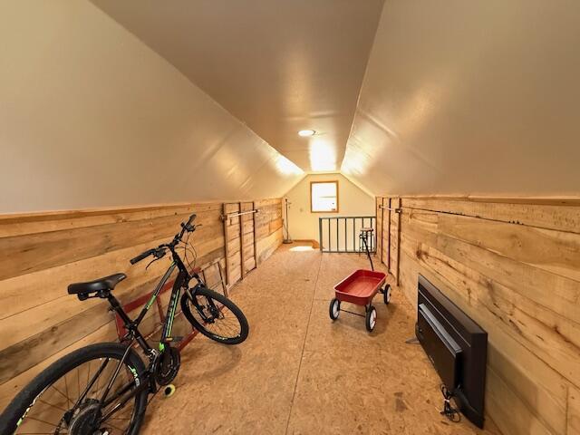 bonus room featuring wooden walls and vaulted ceiling