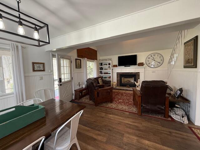 dining area featuring a wainscoted wall, a fireplace, and wood finished floors