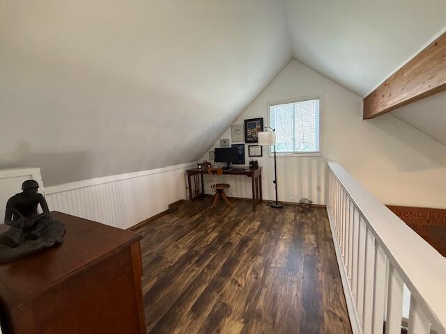 office space featuring vaulted ceiling, dark wood-style floors, and wainscoting