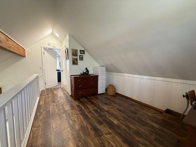 bonus room with lofted ceiling, dark wood finished floors, and wainscoting