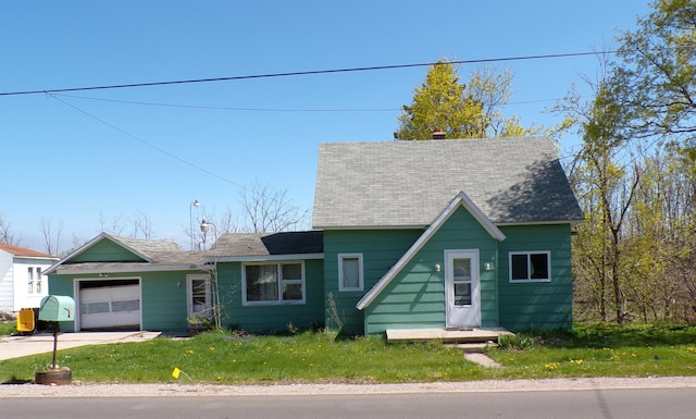 1220 Court St, Cheboygan, MI 49721 - view of front of property with an attached garage, a shingled roof, a front yard, and concrete driveway