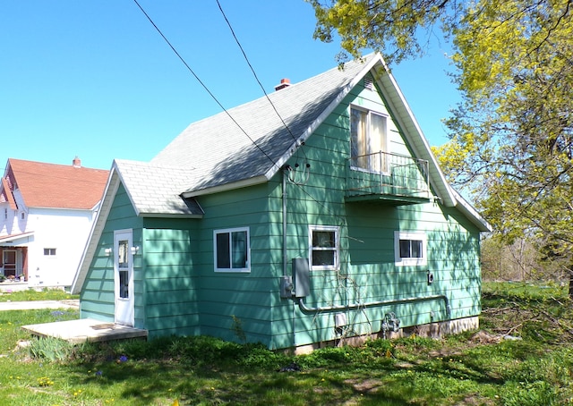 1220 Court St, Cheboygan, MI 49721 - view of property exterior featuring roof with shingles