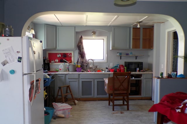 1220 Court St, Cheboygan, MI 49721 - kitchen with freestanding refrigerator, black microwave, gray cabinetry, and light countertops