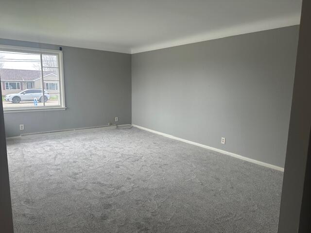 carpeted empty room with baseboards