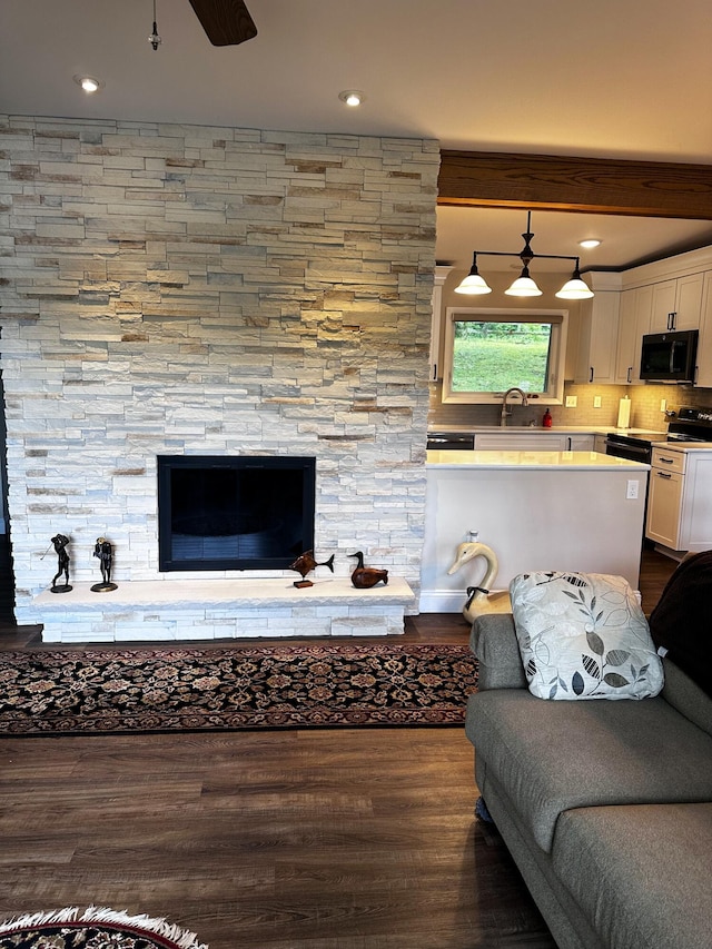 2403 N Perch Lake Dr, Gaylord, MI 49735 - living area with dark wood finished floors, a stone fireplace, recessed lighting, and a ceiling fan