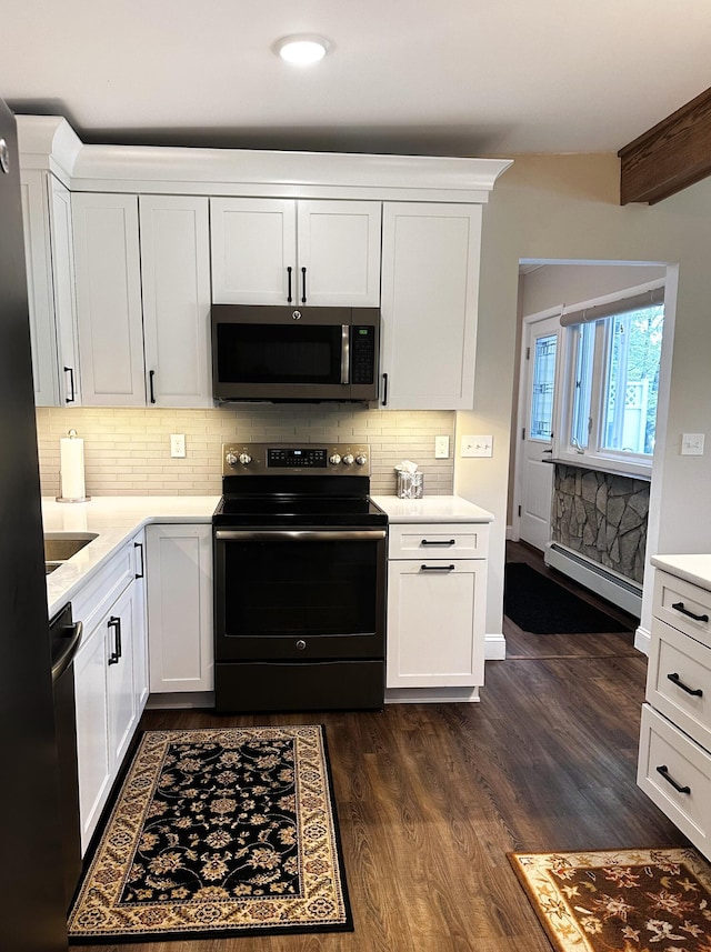 2403 N Perch Lake Dr, Gaylord, MI 49735 - kitchen with appliances with stainless steel finishes, a baseboard heating unit, light countertops, white cabinetry, and dark wood-type flooring