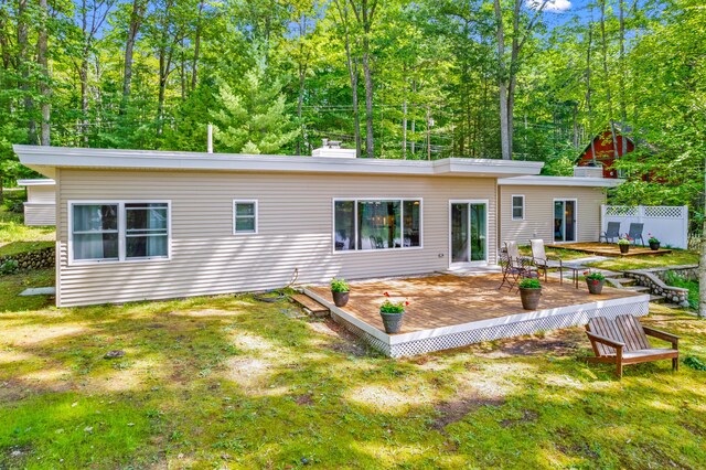 2403 N Perch Lake Dr, Gaylord, MI 49735 - rear view of house featuring a deck, a lawn, and a chimney
