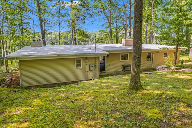 2403 N Perch Lake Dr, Gaylord, MI 49735 - rear view of house featuring a chimney and a yard