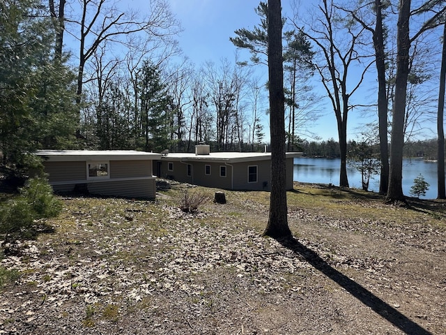 2403 N Perch Lake Dr, Gaylord, MI 49735 - view of front of house with a water view, a chimney, and view of scattered trees
