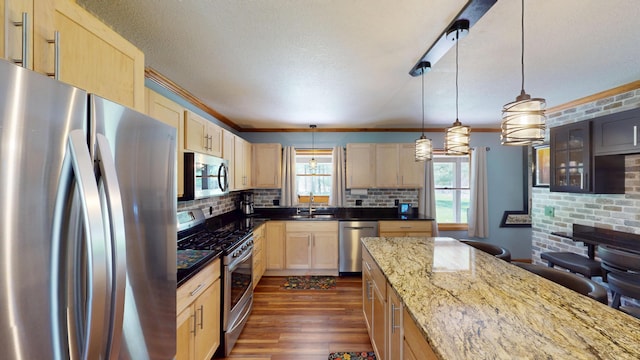 3400 Thornapple Trl, Lewiston, MI 49756 - kitchen with stainless steel appliances, light brown cabinetry, a sink, crown molding, and backsplash