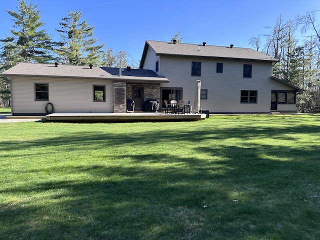 3400 Thornapple Trl, Lewiston, MI 49756 - rear view of property featuring a deck, a lawn, and a sunroom
