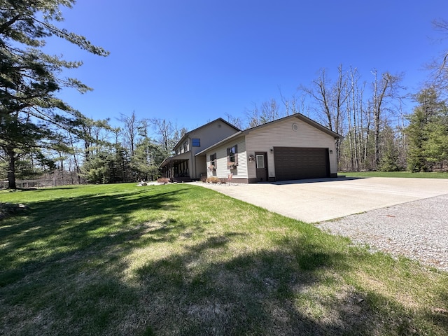 3400 Thornapple Trl, Lewiston, MI 49756 - view of side of property featuring concrete driveway, an attached garage, and a lawn