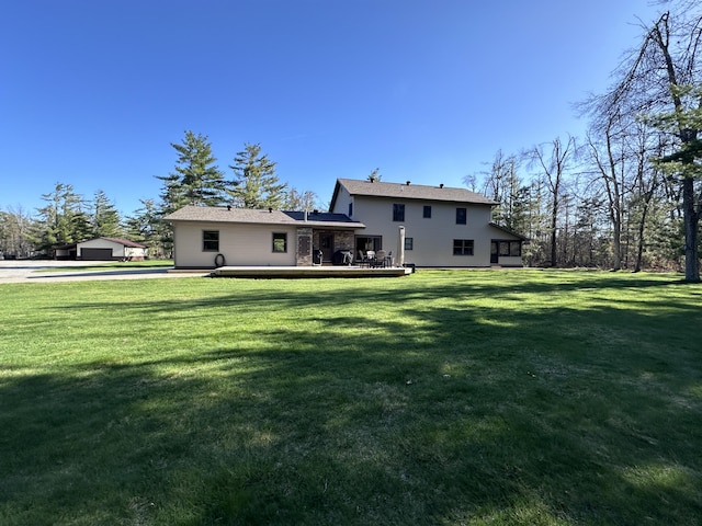 3400 Thornapple Trl, Lewiston, MI 49756 - rear view of house with a lawn and a deck