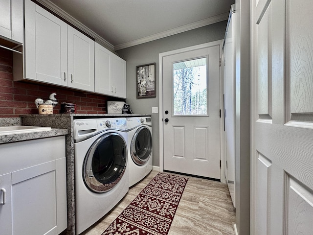 3400 Thornapple Trl, Lewiston, MI 49756 - laundry area with washing machine and clothes dryer, cabinet space, crown molding, and light wood finished floors