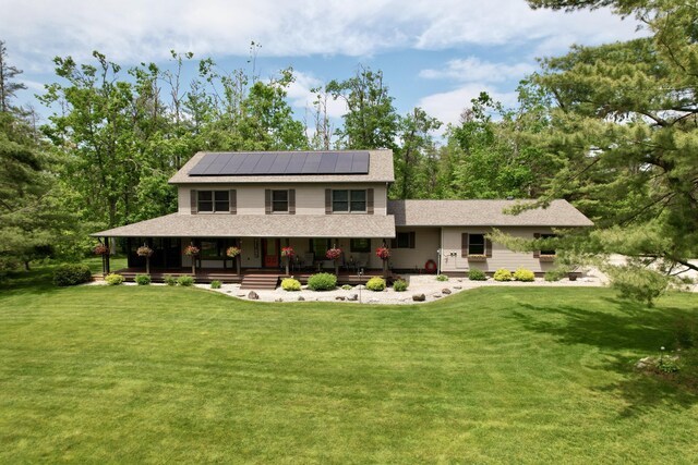 3400 Thornapple Trl, Lewiston, MI 49756 - view of front facade with covered porch, solar panels, and a front lawn