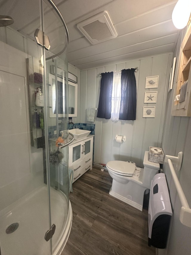 bathroom featuring a shower stall, wood finished floors, toilet, and vanity