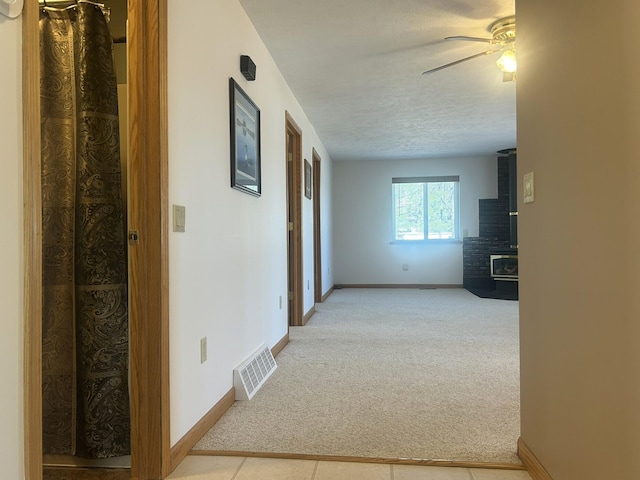 corridor featuring light carpet and baseboards