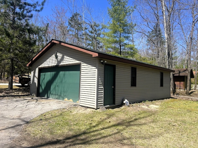 detached garage with asphalt driveway