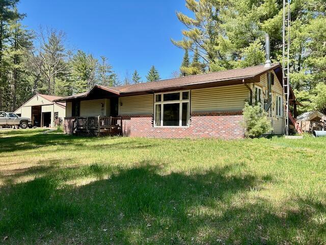 2165 E Cherry Creek Rd, Fairview, MI 48621 - back of property with a yard and brick siding
