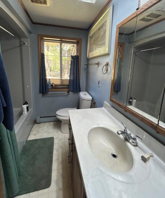 2165 E Cherry Creek Rd, Fairview, MI 48621 - full bath with a baseboard radiator, toilet, vanity, tile patterned floors, and a textured ceiling