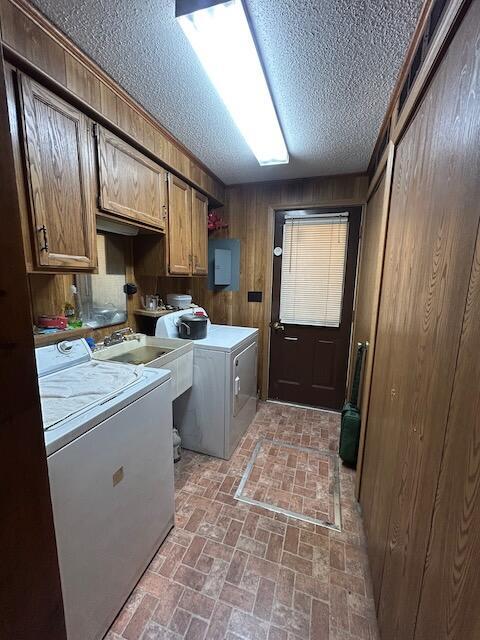 2165 E Cherry Creek Rd, Fairview, MI 48621 - laundry area with cabinet space, brick patterned floors, wooden walls, a textured ceiling, and washing machine and clothes dryer
