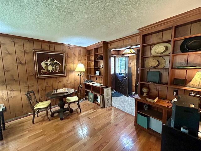 2165 E Cherry Creek Rd, Fairview, MI 48621 - sitting room with hardwood / wood-style floors, wooden walls, and a textured ceiling