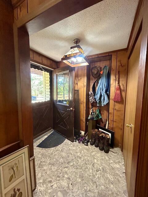 2165 E Cherry Creek Rd, Fairview, MI 48621 - entryway featuring a textured ceiling and wooden walls
