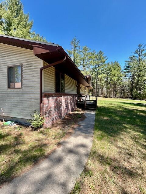 2165 E Cherry Creek Rd, Fairview, MI 48621 - view of property exterior featuring crawl space, a yard, and brick siding