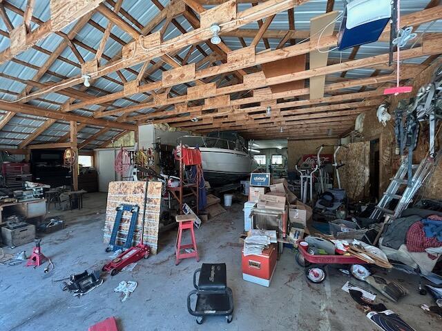 2165 E Cherry Creek Rd, Fairview, MI 48621 - miscellaneous room with a garage, vaulted ceiling, and concrete floors