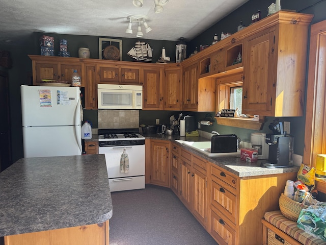 kitchen with white appliances, brown cabinets, dark countertops, and light colored carpet