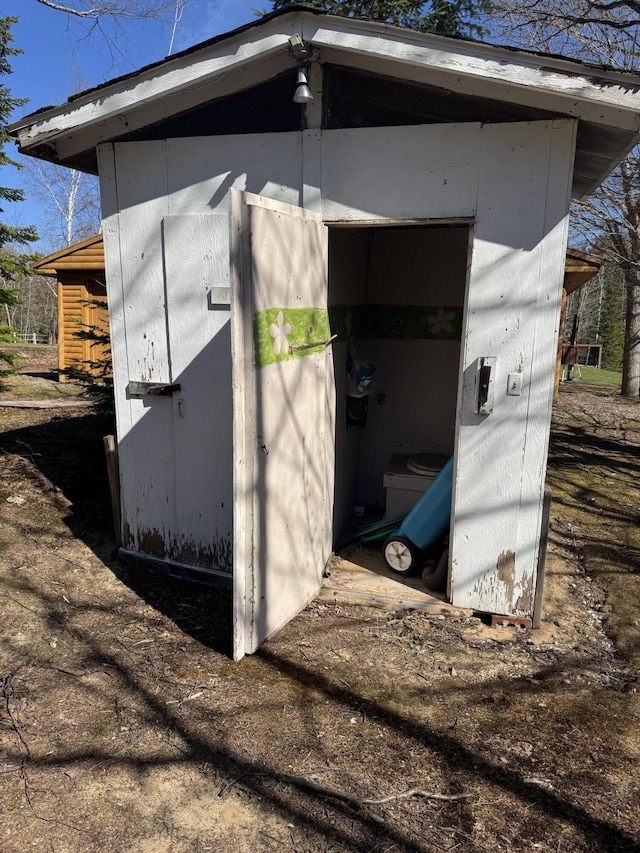 entry to storm shelter with an outdoor structure and a storage shed
