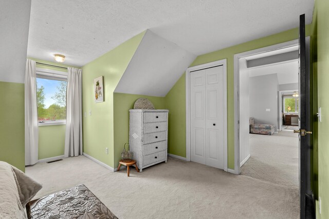 201 Country Ct, Houghton Lake, MI 48629 - carpeted bedroom with multiple windows, baseboards, lofted ceiling, and a textured ceiling